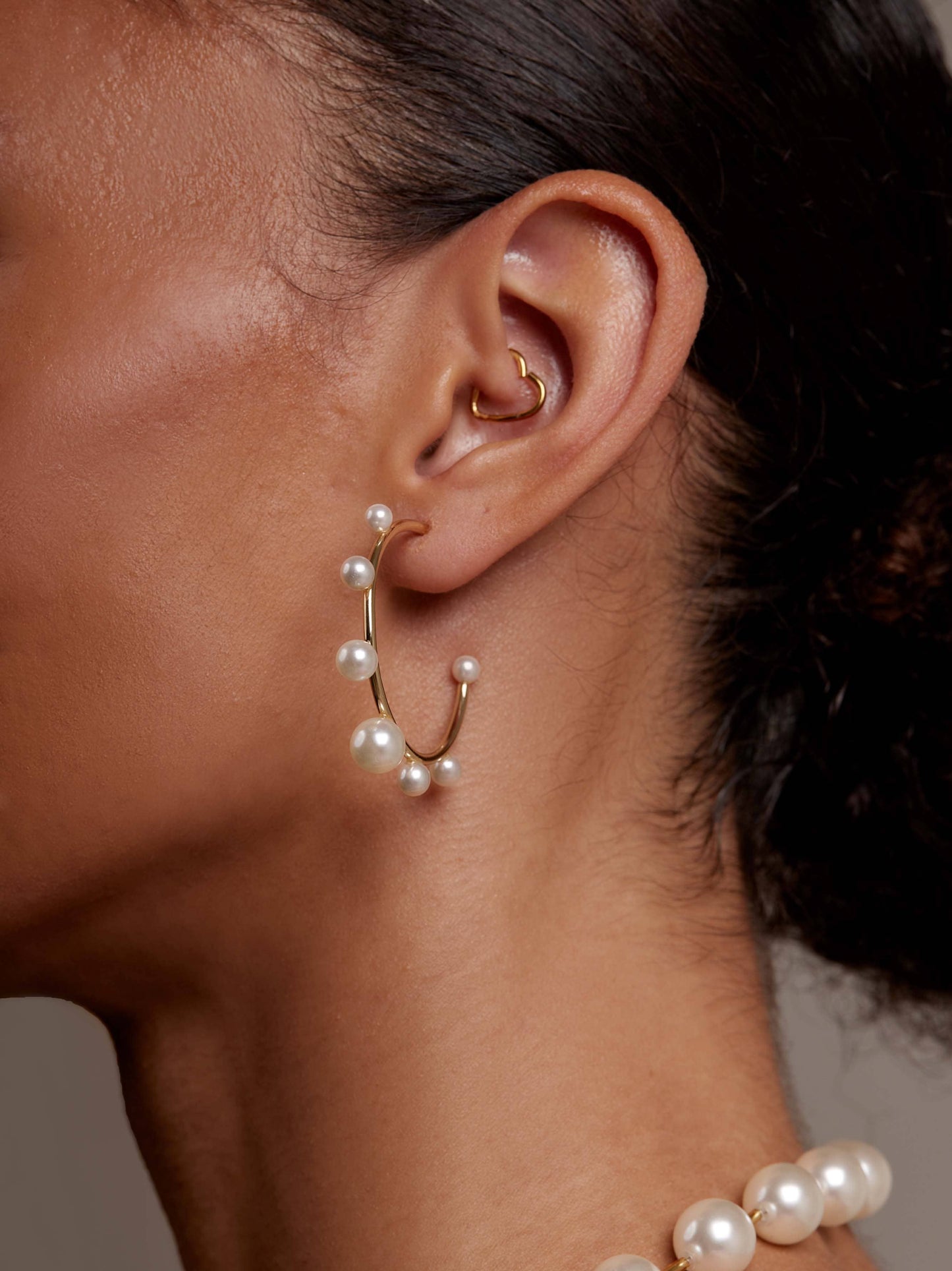 Small, gold-tone hoop earring embellished with spaced